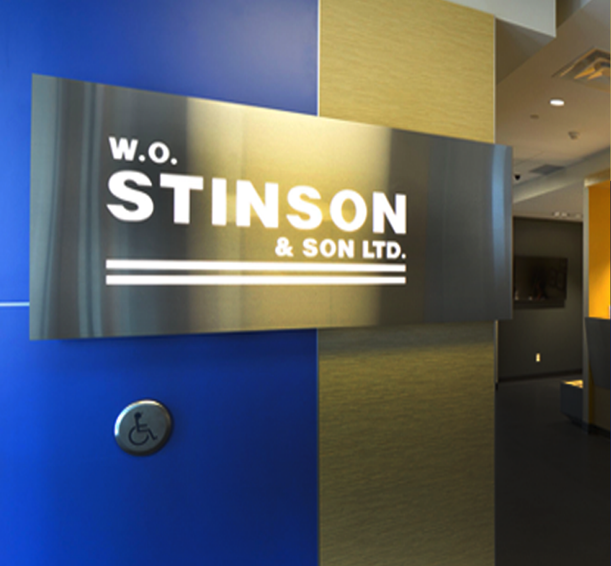 Image of the inside of the Stinson corporate head office entryway with a stainless steel sign with the Stinson logo on it