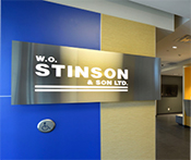 Image showcasing the interior of the entryway at the Stinson corporate head office. It features a stainless steel sign adorned with the Stinson logo
