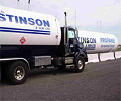 Image of a propane tank with a delivery truck beside it