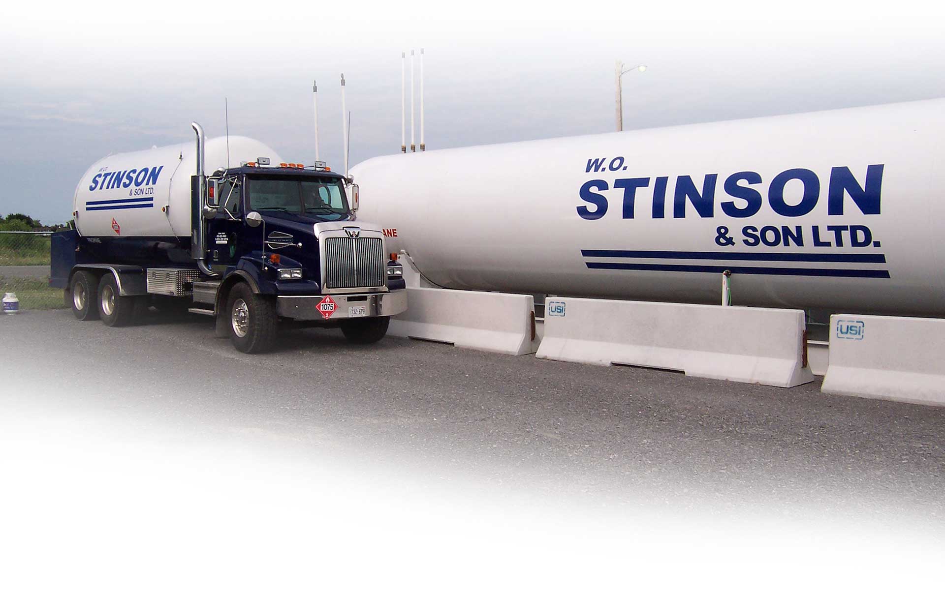 Image of a Stinson delivery truck beside a large cylinder propane tank